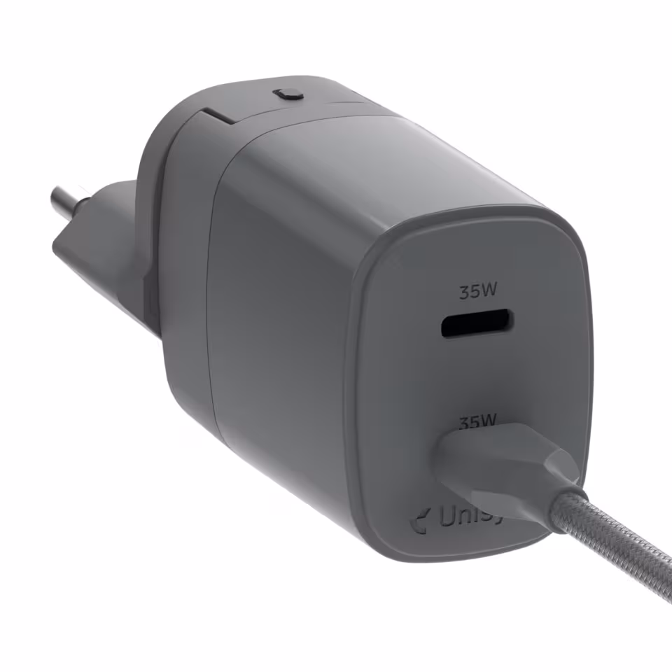Unisynk kompakt USB-C-laddare med två portar och reseadaptrar – grå design mot vit bakgrund.